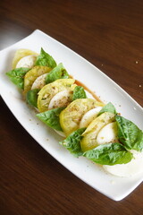 Yellow tomato caprese salad with mozzarella cheese