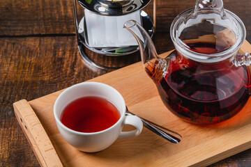 Healthy herbal tea brewed from red herbs and fruits in a white porcelain cup