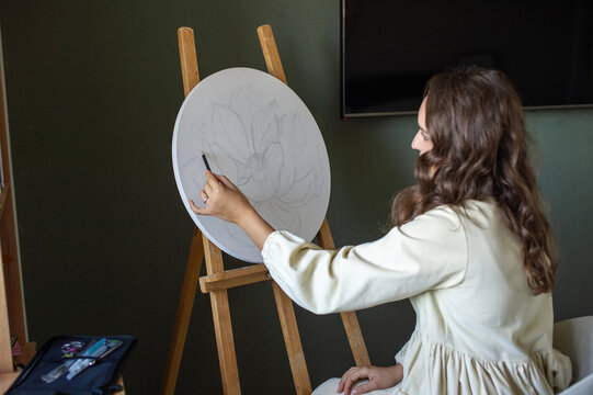 Artist Sketching Floral Design on Canvas in Studio
