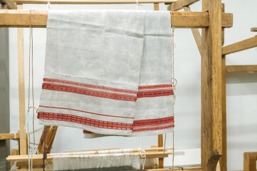 Traditional textile with red stripes on wooden loom display