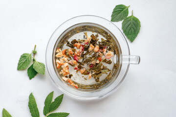 Process brewing tea, tea ceremony. Cup of freshly brewed black tea,warm soft light and fresh leaves