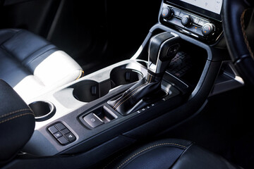 Fototapeta premium automatic transmission shift selector in the car interior. Closeup a manual shift of modern car gear shifter. 4x4 gear shift