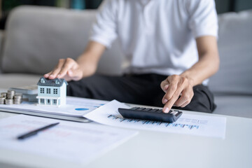 Saving money. Man calculate finances home pay bills taxes savings economy financial at home and saving money stacking coins with calculator