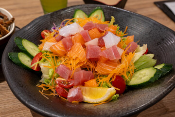 This vibrant image showcases a colorful and refreshing sashimi salad, featuring a mix of fresh, raw fish like salmon and tuna,  tossed with crisp vegetables. 