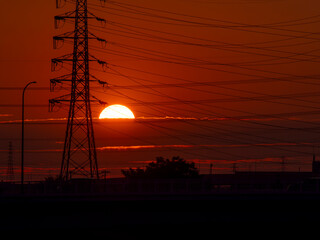 真っ赤な夕日と送電鉄塔