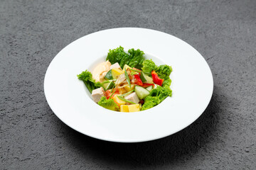 Fresh vegetable salad with chicken. On a gray background.