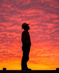 Construction worker silhouette against a stunning sunset sky.