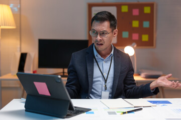 Businessman wearing glasses suffers from stress, eye strain, headaches when working and searching for financial information, statistics, graphs, income charts. Work online on a laptop computer.
