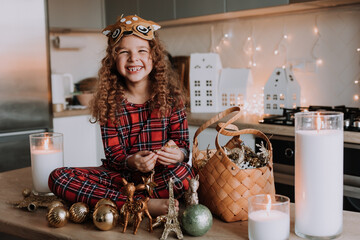 Happy little girl with Christmas toys at home