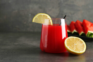 Delicious watermelon drink in glass and fresh fruits on dark grey table. Space for text
