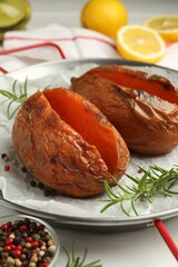 Tasty cooked sweet potatoes served with rosemary on table, closeup