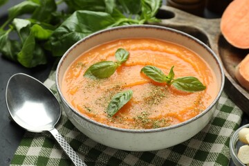 Delicious sweet potato soup in bowl served on grey table, closeup