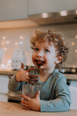 little boy with curly hair eats cocoa for Christmas