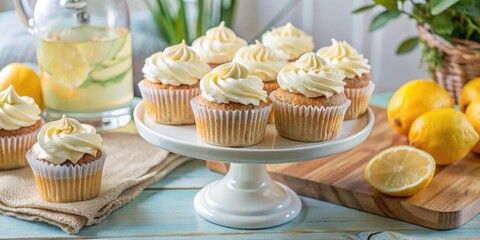 Lemon cupcakes with creamy frosting on a white cake stand for dessert