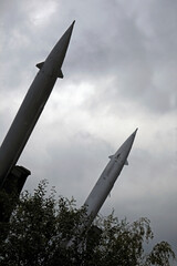 Two missiles pointing at a dramatic sky