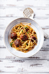 Spaghetti Pasta with Meatballs and fresh Basil o bright background. Top view.