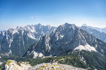 The majestic Skrlatica, Prisank, and Triglav mountains rise dramatically in the Julian Alps,...
