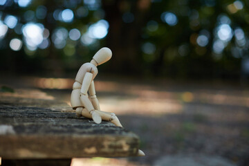 秋の公園のベンチに座る可愛いマネキン人形の様子