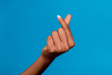 Cropped close up photo of lady hand fingers make korean love heart gesture isolated on blue color background