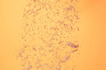 Winter snow falling flying over sunset evening orange sky. Snow dust falling throwing in sunlight sunset on orange evening, yellow background isolated