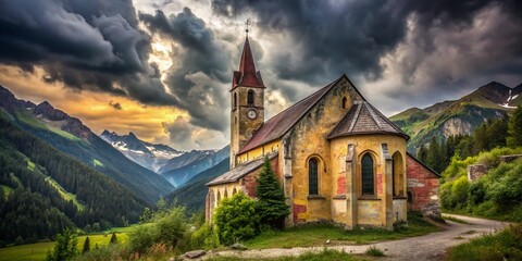 Fototapeta premium Heiligenblut Osttirol: A forgotten church lies beneath the majestic Großglockner.