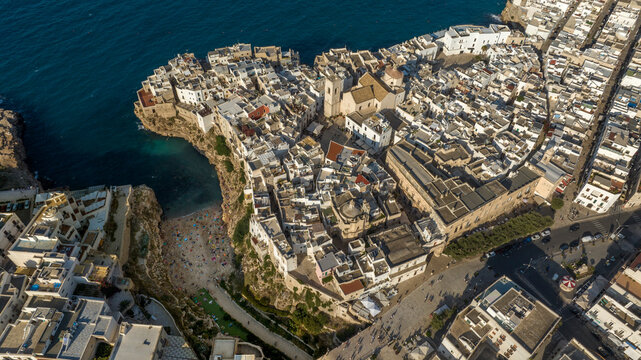 Aerial view at sunset of the historic center of Polignano a Mare, in the province of Bari, Puglia, Italy. On the left is Lama Monachile beach, the most important and famous beach in town.