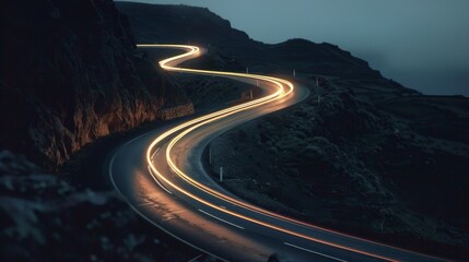 The winding road follows the curves of the jagged cliffs its path marked by a trail of shimmering car lights.