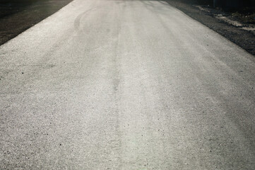 The photo shows a close-up of grey asphalt road