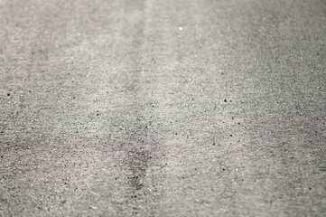 The photo shows a close-up of grey asphalt road