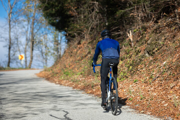 Man riding a bike on the road in the forest
