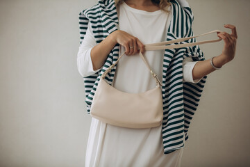 Model, woman, hands close-up with a handbag in a dress, on a white background