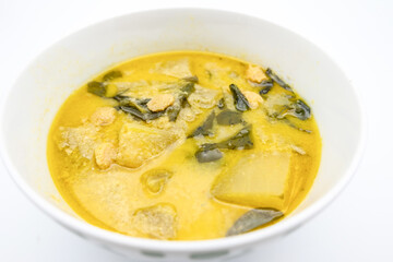 A vibrant bowl of green soup with leafy greens and chunks of meat, showcasing a hearty and comforting dish.