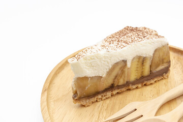 Banoffee Pie, whipped cream and banana on the wooden plate isolate white background