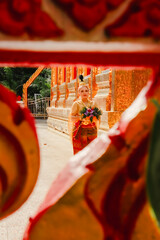 Ancient Thai woman walks with a krathong during the Loi Krathong festival around a beautiful temple in Thailand.