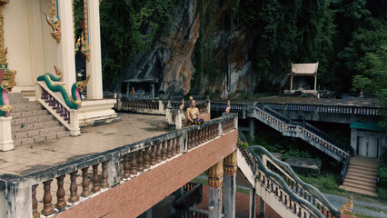 Ancient Thai woman walks with a krathong during the Loi Krathong festival around a beautiful temple in Thailand.