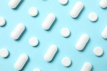 White medicine pills on color background