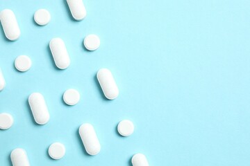 White medicine pills on color background