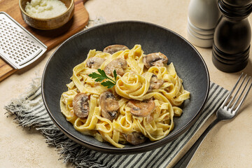 Creamy Alfredo pasta tagliatelle or fettucine with mushrooms, onion and vegan cream sauce.  Italian meal.
