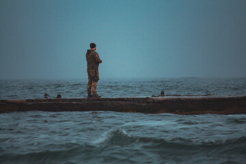 Soldier on Pier in Stormy, Foggy Weather