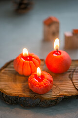Small bright orange candles in the shape of a tangerine