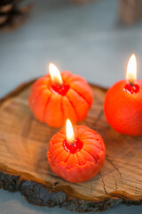 Small bright orange candles in the shape of a tangerine