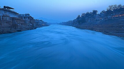 A serene view of a river flowing through a city at dusk, with buildings on both sides of the river.