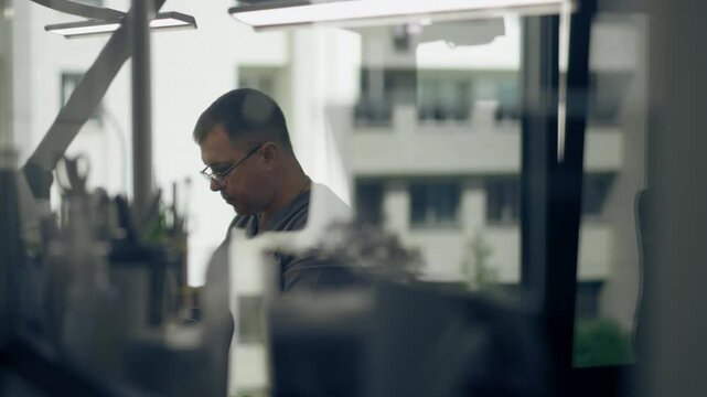 professional laboratory for the production of dental protoses veneers and crowns a specialist adjusts a crown to the shape of a person's jaw gums professional equipment