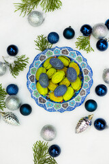 Christmas or New Year green and blue homemade cookies called Nuts stuffed with condensed milk and walnuts surrounded with Christmas balls 