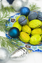 Christmas or New Year green and blue homemade cookies called Nuts stuffed with condensed milk and walnuts surrounded with Christmas balls 