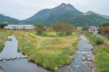 Yufuin village, river, Yufu mountain and blue sky with cloud background, Yufuin, Oita, Kyushu, Japan