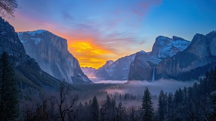 Obraz premium A breathtaking sunrise over a mountainous landscape, with misty valleys and snow-capped peaks.