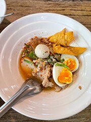 The closed up of Thai noodles with meat ball. Select and soft focus. Asian noodle soup with beef meatball with fresh vegetable on wood table.  Hot and spicy noodle soup, Asian food.