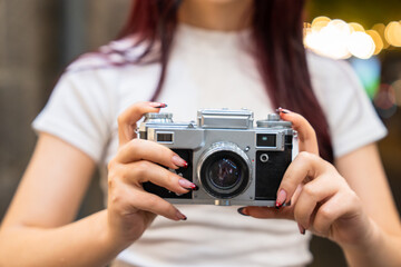 Naklejka premium The camera in the hands of a young girl, aesthetic, photography concept