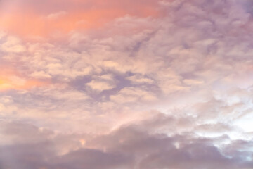 Soft pink and purple clouds in a colorful sunset sky. Abstract nature background. Design for wallpaper, poster, banner, greeting card, invitation.
